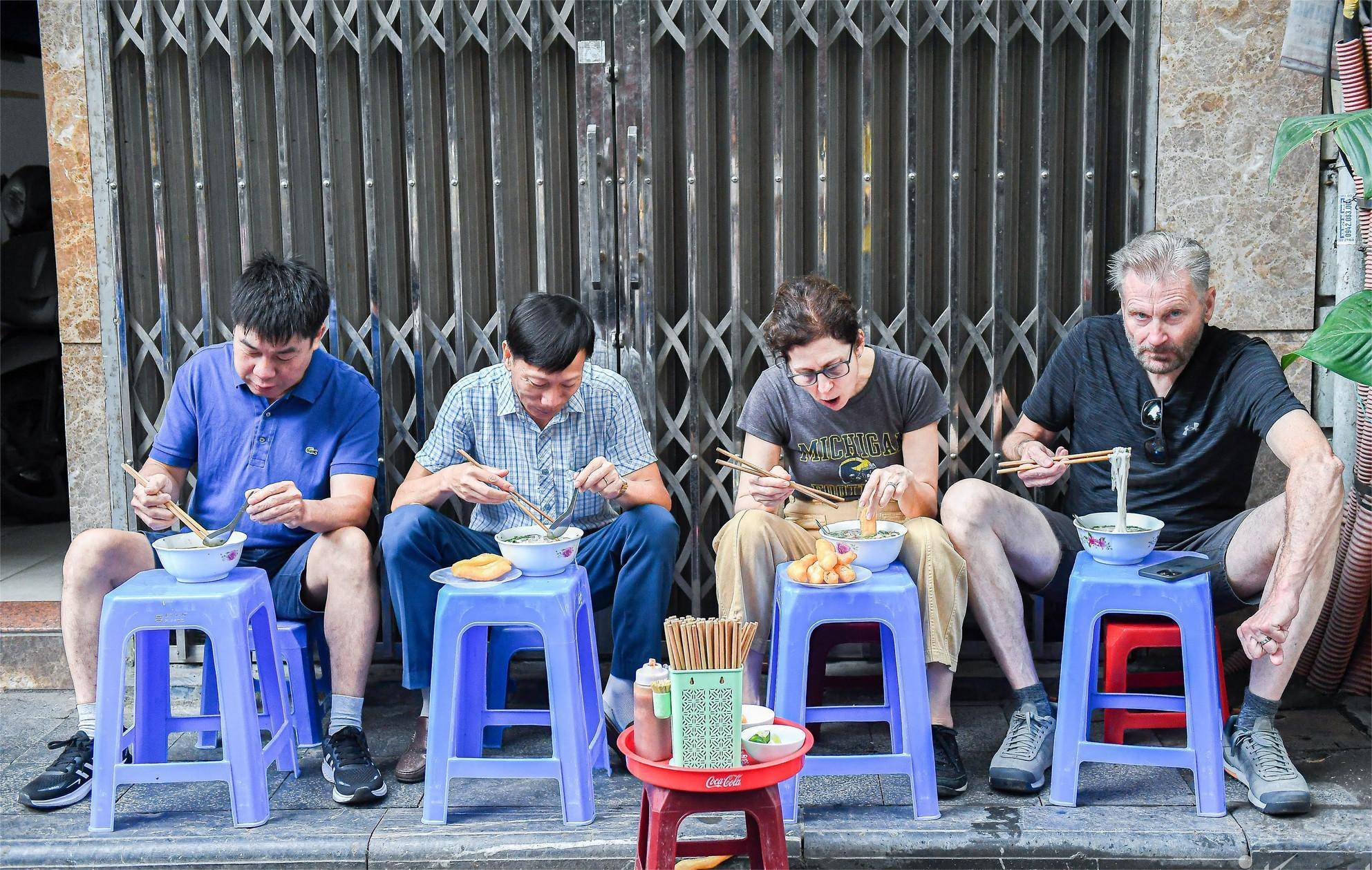 Du khách thưởng thức phở Tư Lùn trên vỉa hè