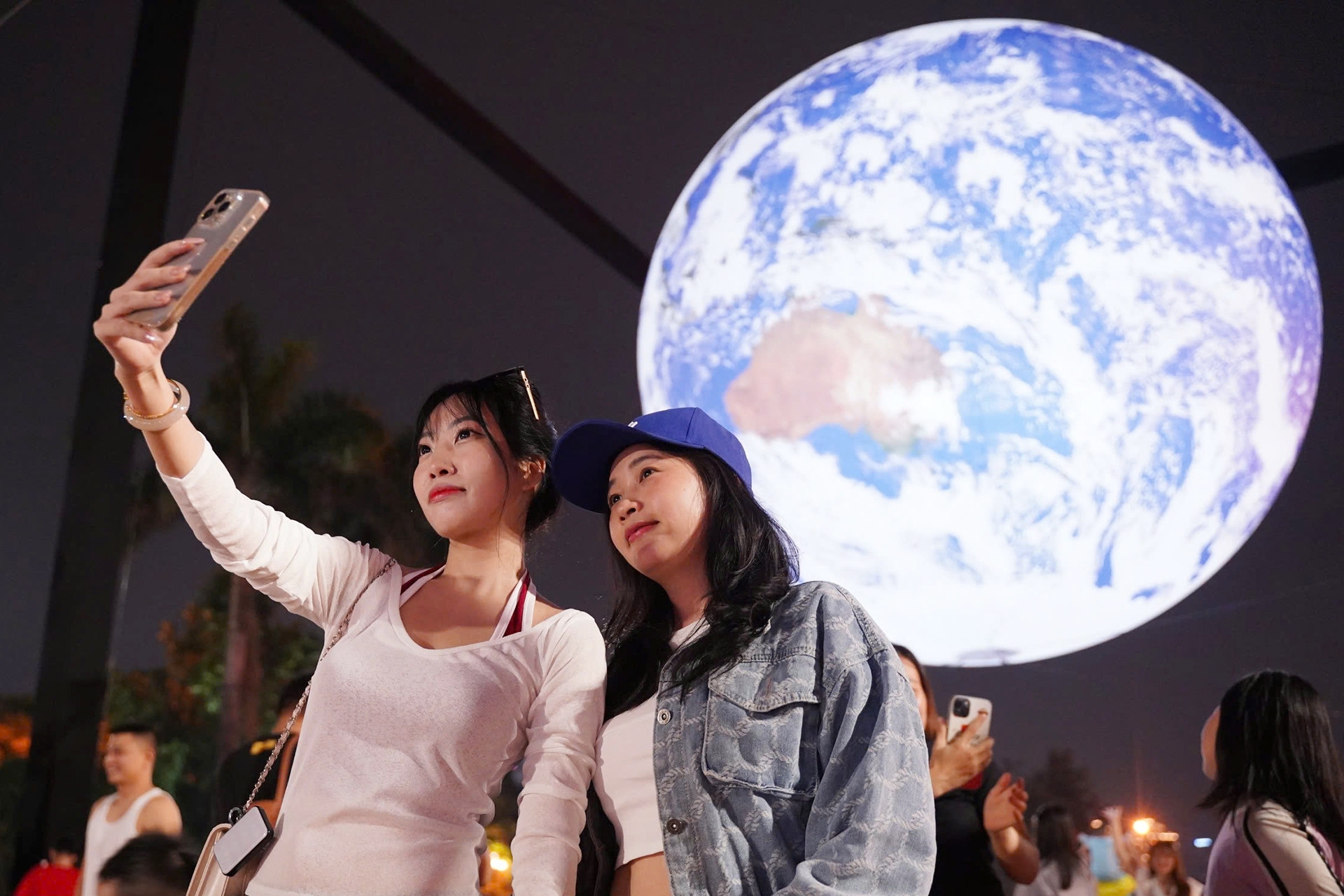 Du khách check in bên mô hình trái đất